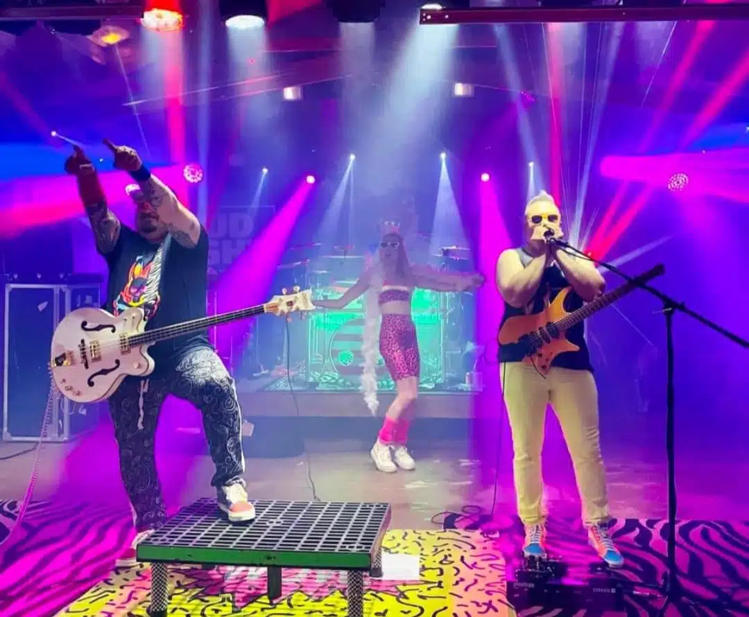 An 80's band playing on a stage.