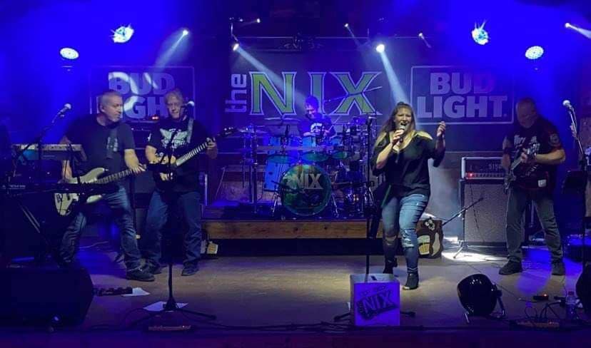 The NIX band playing on a stage.